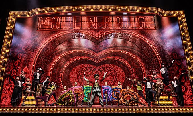 Cameron Blakely as Harold Zidler and the original world tour company of MOULIN ROUGE! THE MUSICAL